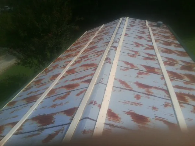 Rusted metal roof panels with new wood purlins before replacement — Storm Damage Roof Repair in Mackey by Roofing Brothers